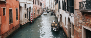 Picture of an hand putting a polaroid of Venice in the middle of a canal